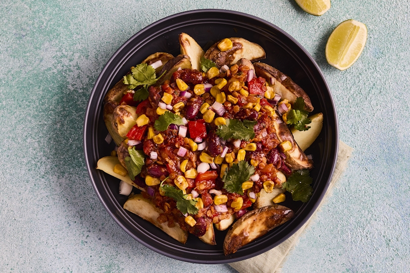 Are you ready to take chilli night to the next level? Seasoned potato wedges are smothered with a warming vegan chilli packed with filling lentils and kidney beans. Scatter with blackened corn and coriander, squeeze over lashings of lime and settle in for a good time.