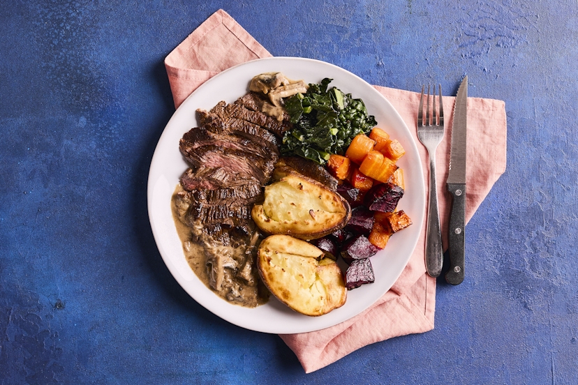 Raise the steaks at dinner time with this mouth-watering feast. Bavette steak (known as the butcher’s cut) is flash-fried and served with cavolo nero and roast potatoes, carrots and beets, with a garlicky mushroom and shallot sauce. Crushing the potatoes halfway through roasting gives them a gorgeous crispy finish.
