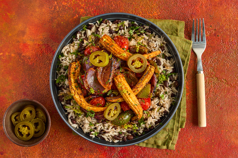 Jalapeño peppers are mildly spiced and give an authentic Tex-Mex kick to this dish. Red onion, pepper, tomatoes and baby corn are char-grilled with our special Mexican spice blend and served on rice and black beans, topped with lime, coriander and jalapeños for a zingy finish.