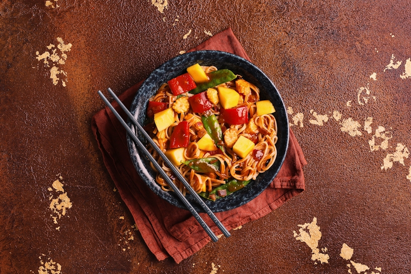Spoil your chopsticks for choice with a scrumptious jumble of sizzled shallots, red pepper, baby corn and brown rice noodles in a quick DIY sweet and sour sauce. The juicy chunks of mango sprinkled on top give a gorgeous fresh and fruity finish.