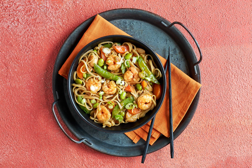 For this lightning-fast stir-fry, carrots, spring onions and sugar snaps are lightly sautéed, then simmered with plump prawns and edamame in a ginger, five-spice and soy sauce. Stir through slurpy rice noodles and there you have it – a mouth-watering masterpiece in just 20 minutes!