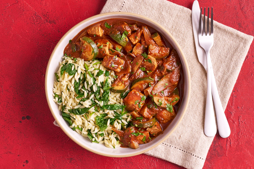 Greek stifado is typically served with rice, but we’ve added a twist with orzo pasta. Chunks of lean pork are cooked with courgettes and shallots in a rich tomato sauce scented with cinnamon, oregano and garlic. The orzo, mixed with baby spinach, soaks up sauce to perfection.
