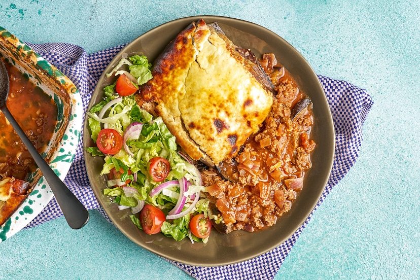 All the comfort of classic moussaka, streamlined for weeknights and healthier than ever. Sink your serving spoon through a lightened-up bechamel-style sauce, soft aubergines and garlicky, cinnamon-spiced beef all baked into one gorgeous, golden-topped dish. On the side, a fresh tomato, red onion and gem lettuce salad adds colour and crunch.