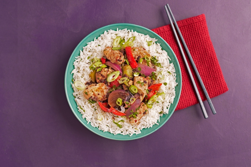 Our take on the classic Chinese stir-fry features sizzling strips of ready-sliced chicken, onions, plus red and green peppers in a deeply savoury sauce made with garlic, ginger, tamari and blitzed black beans. Served on fluffy rice and scattered with fresh coriander and spring onions, it’s your go-to order, minus the wait!