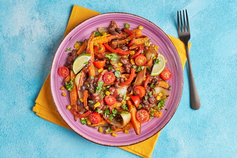 This loaded plateful is satisfying, spicy and proudly unpretentious! So roll up your sleeves, grab a napkin and get stuck into sweet potato chips, roasted onions and corn, smothered with black beans and red pepper in peri-peri sauce, a super-simple baby tomato and coriander topping and lime wedges for a citrussy flourish.
