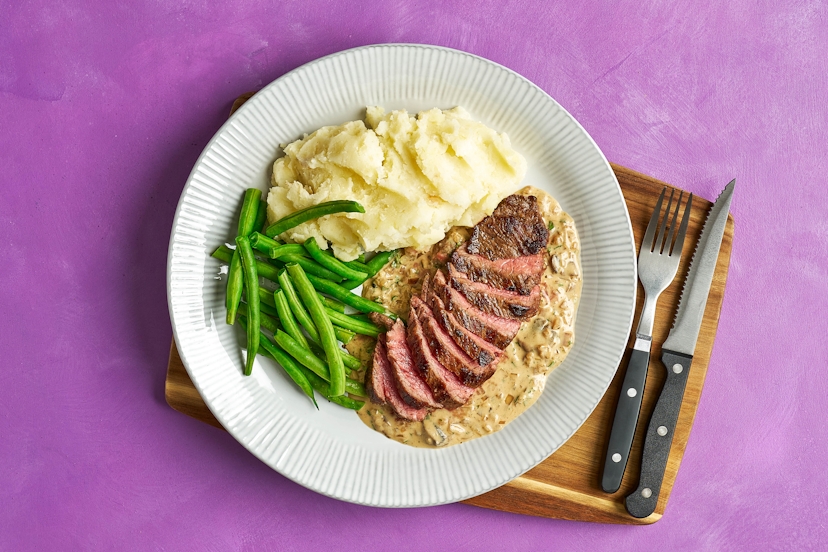 A retro favourite, with a modern glow-up. Juicy steaks are smothered in a rich mushroom, shallot and garlic sauce, made creamy with Greek-style yogurt and whipped up in the same pan to catch every last bit of flavour. Served with fluffy mash and sautéed greens, it has all the deliciousness of the classic, just without the flambé theatrics.