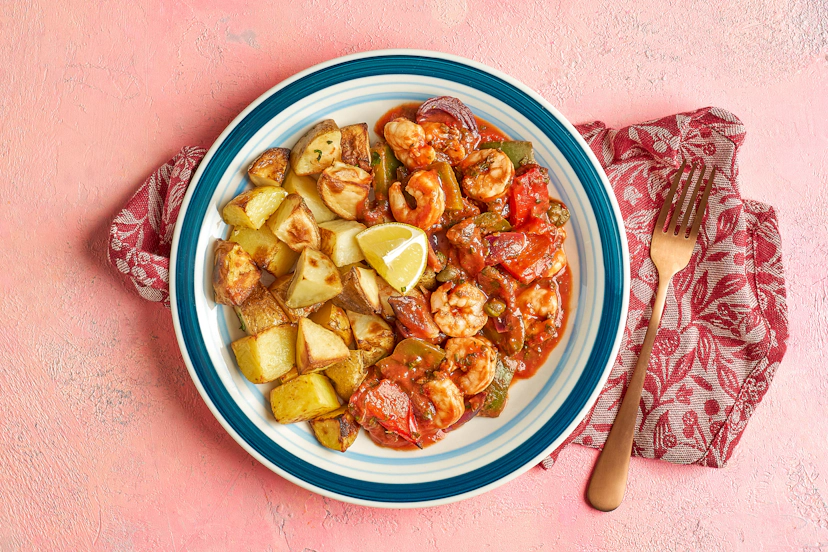 Set sail for Aegean sunsets with this sun-kissed supper. Cubed potatoes are oven-roasted with onions and peppers, and perked up with basil, mint and oregano. Plump prawns, capers and chilli join the action, with a dash of passata and squeeze of lemon, before emerging as a bubbling bake worth launching a thousand ships for.