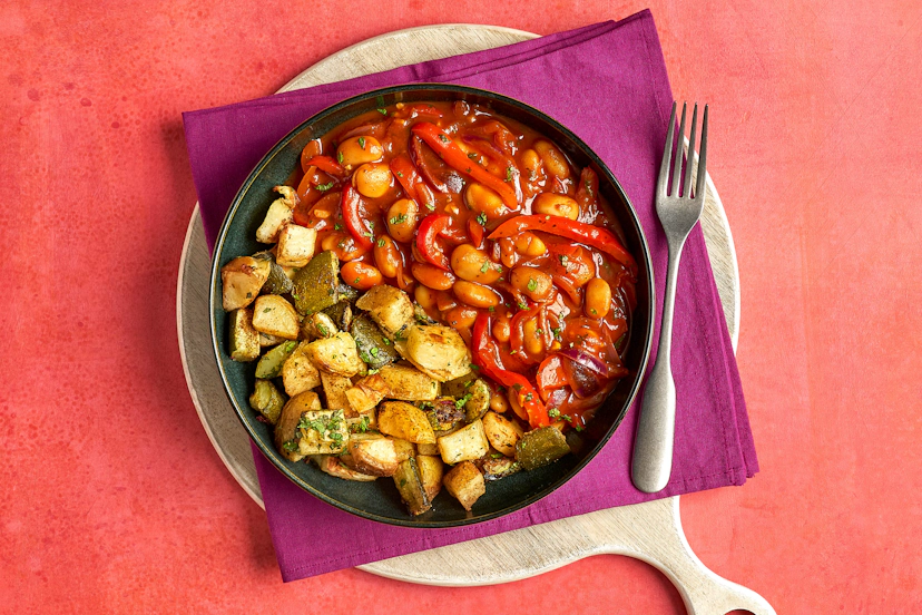 Some dishes can make you feel cosy and at home; others nudge you out of your comfort zone. This gently warming stew does both! Creamy butter beans, sizzled red onion and sweet romano peppers in a harissa-spiced tomato sauce provide the warm-fuzzies, while ras el hanout-roast potatoes tossed with cooling mint add a welcome sense of adventure.