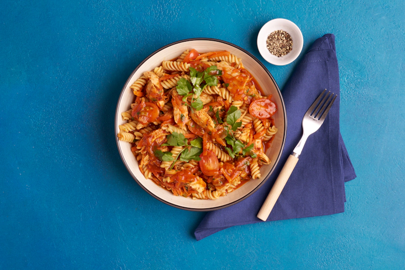 Ooh-mami, this super-savoury chicken dish is quite the flavour bomb! While chicken breasts grill and pasta simmers, stir up a speedy sauce of spring onion and carrot zhuhed up with our special pastes – sun-dried tomato and garlic – and a smoky paprika and oregano blend. With tamari, balsamic and passata upping the ooh-factor, all that remains is to shred the chicken, chop the coriander and bring everything together!