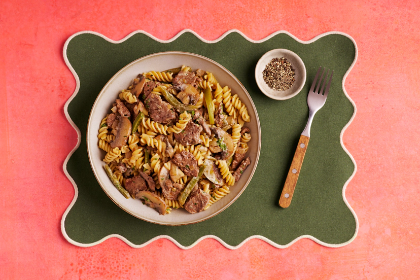 Pasta night has come out punching! Featuring juicy strips of steak, mushrooms and green peppers, twists of fusilli and a peppy green peppercorn and garlic sauce made creamy with yogurt, this dish is a knockout.