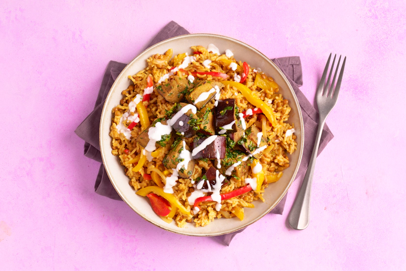 If baked rice isn't on your radar, it's time to get this easy-peasy pilaf in your repertoire! Fry onions and peppers with ginger, garlic and ras el hanout, then bake to perfection in the oven with rice, lentils and stock. Aubergine spiced, softened and stirred through with fragrant herbs makes the perfect partner.